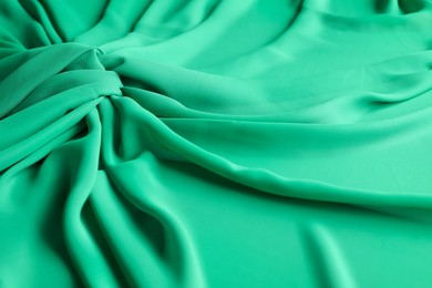 Photo of Beautiful green tulle fabric as background, closeup