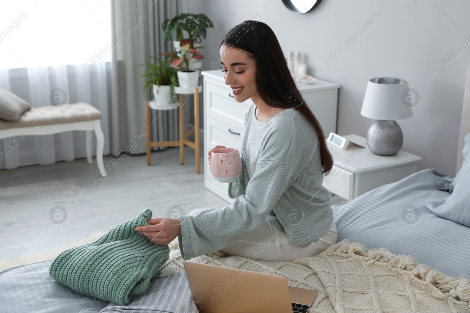 Photo of Young woman choosing clothes for work day at home. Morning routine
