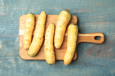 Photo of Raw white carrots on blue wooden table, top view