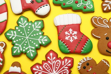 Different tasty Christmas cookies on yellow background, flat lay