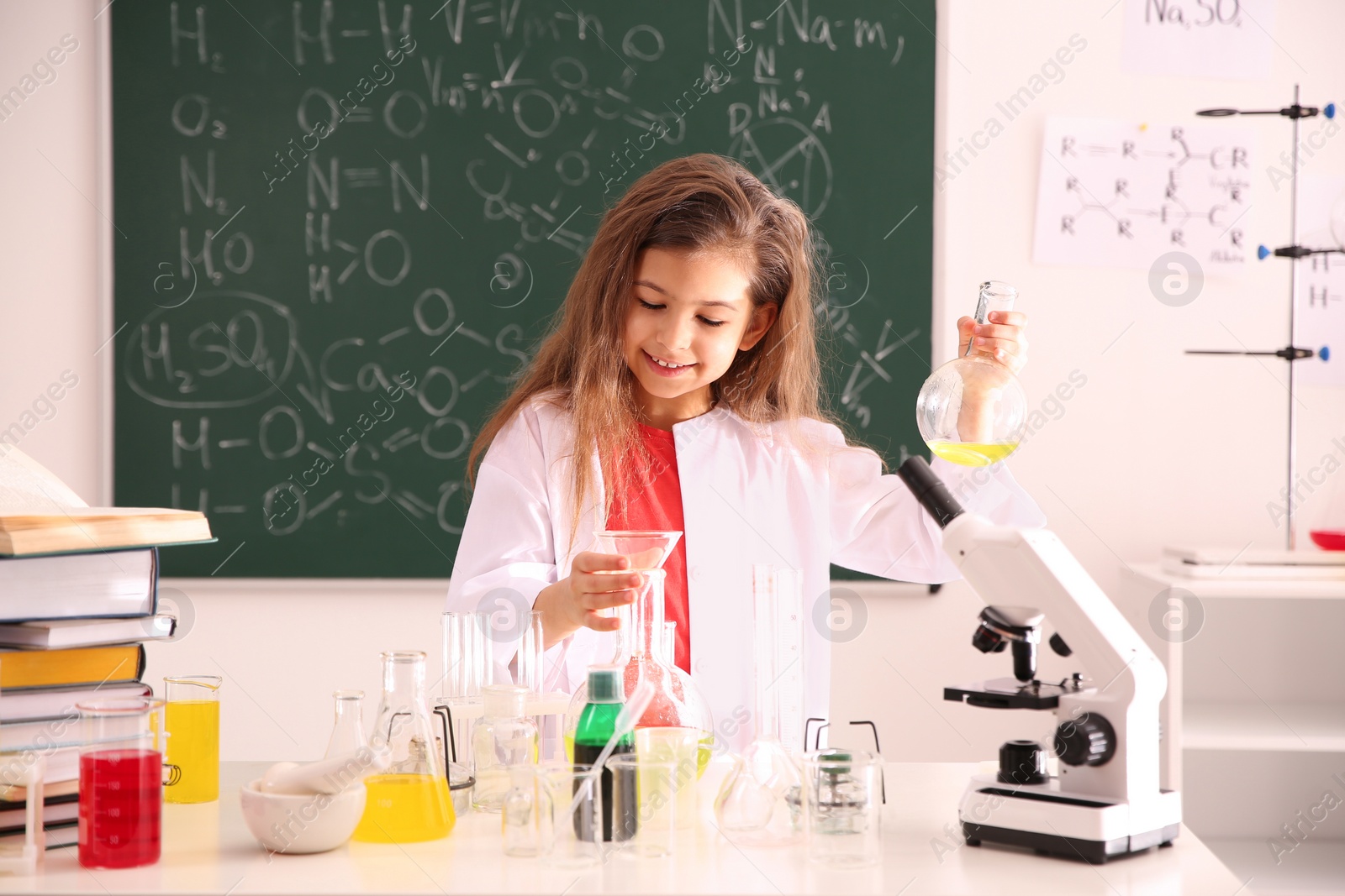 Photo of Schoolchild making experiment at table in chemistry class