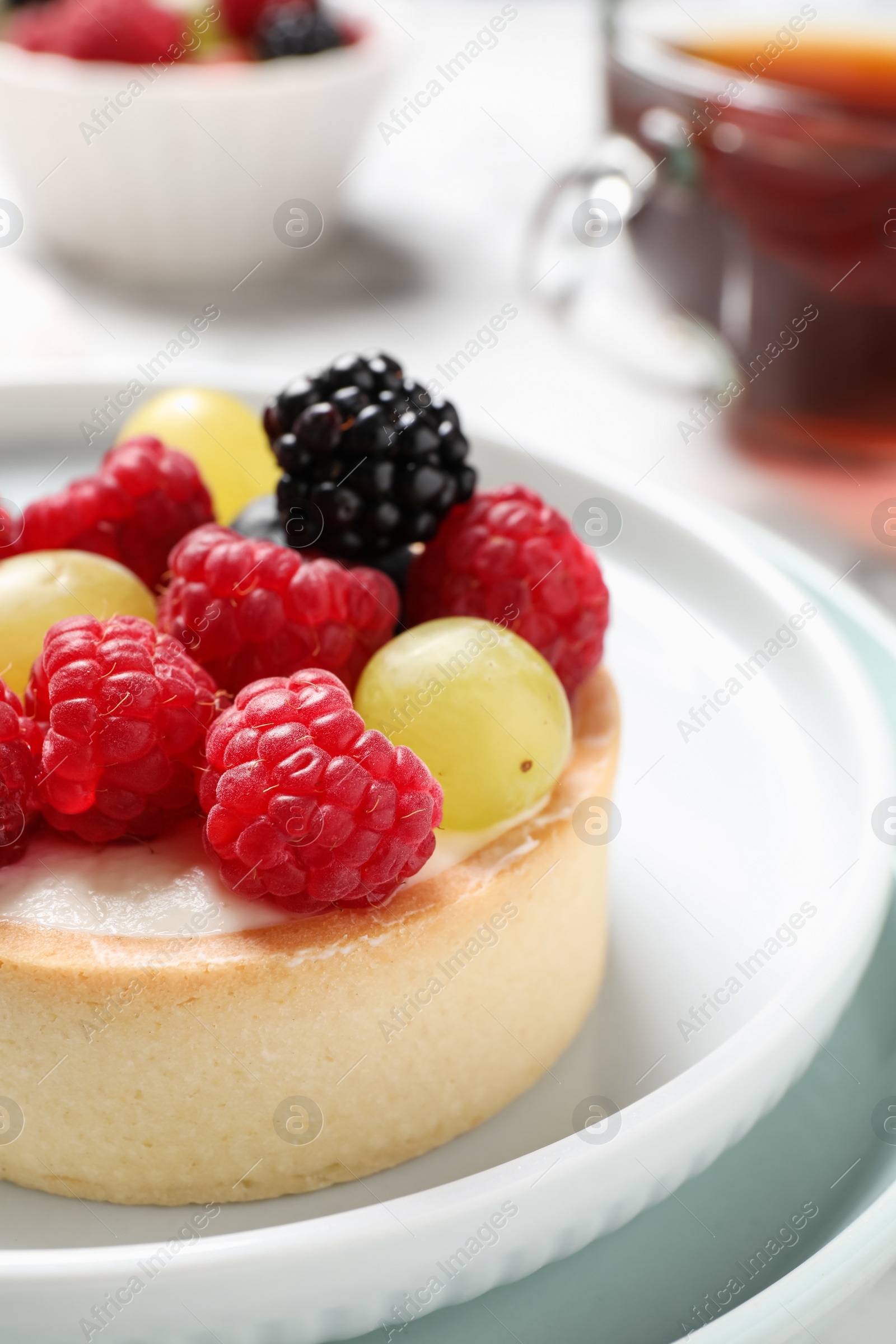 Photo of Delicious tartlet with berries on plate, closeup