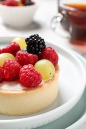 Photo of Delicious tartlet with berries on plate, closeup