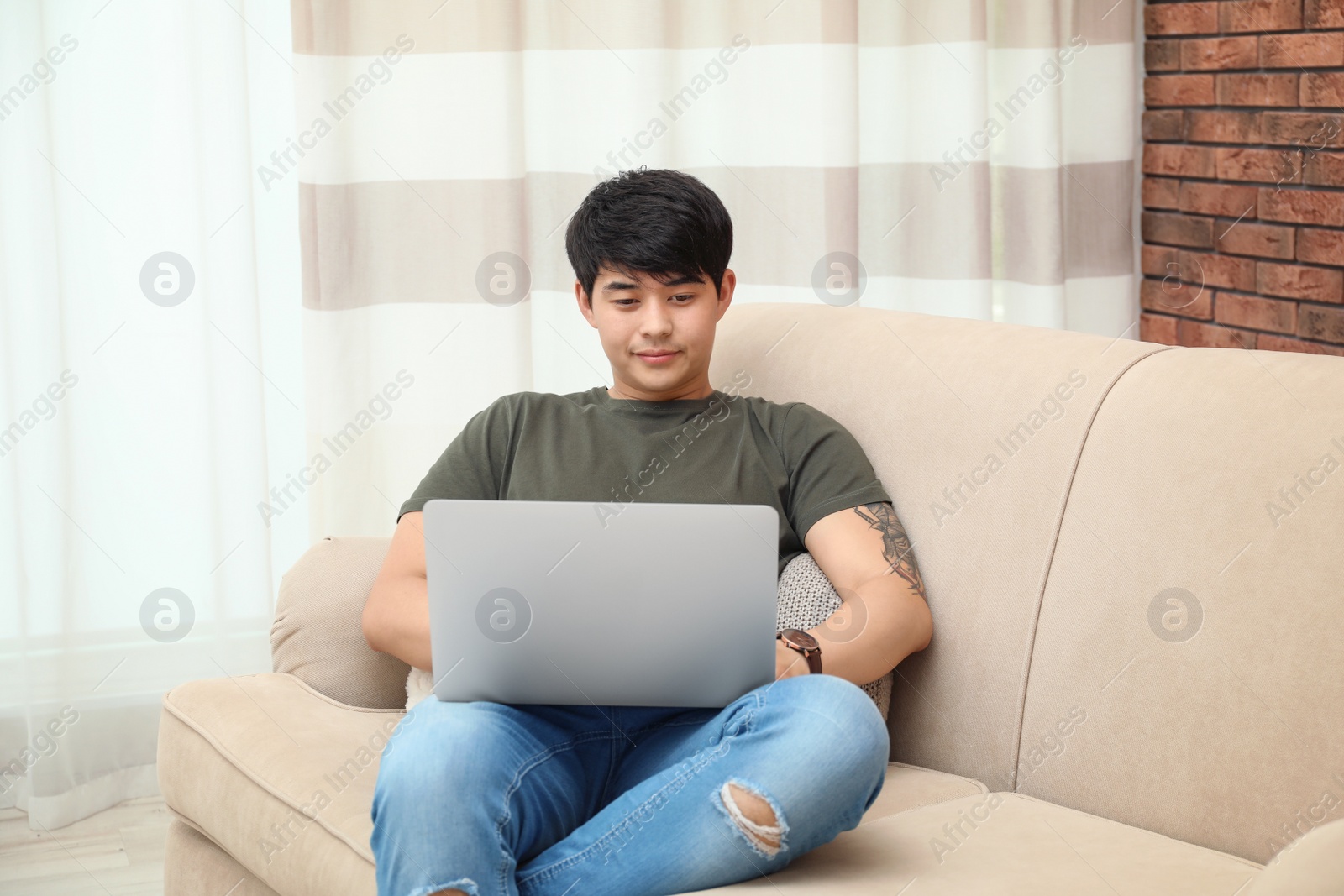 Photo of Man in casual clothes with laptop in living room