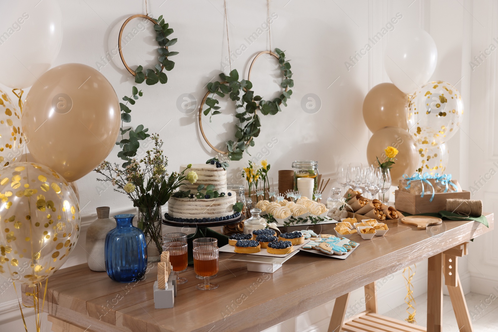 Photo of Beautiful cake and other treats on table in room. Baby shower party