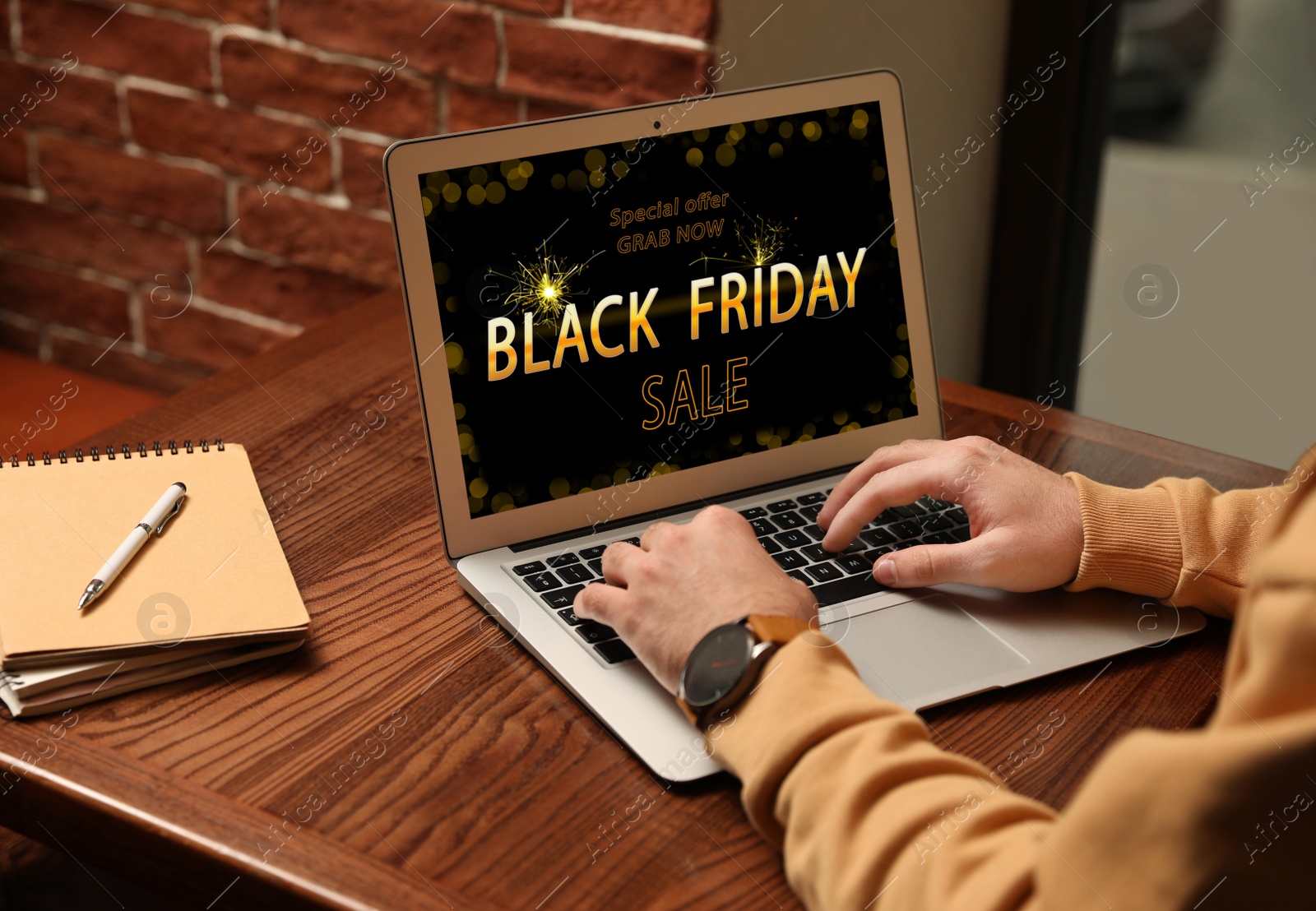 Image of Black Friday. Man shopping online using laptop at table, closeup