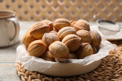 Photo of Bowl of delicious nut shaped cookies on grey wooden table, closeup