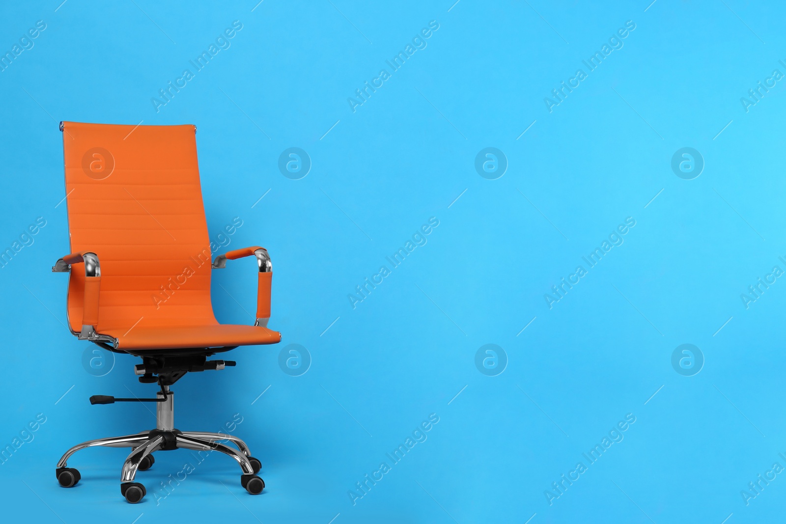 Photo of Comfortable office chair on light blue background, space for text