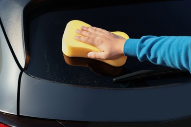 Photo of Man washing car with sponge outdoors, closeup