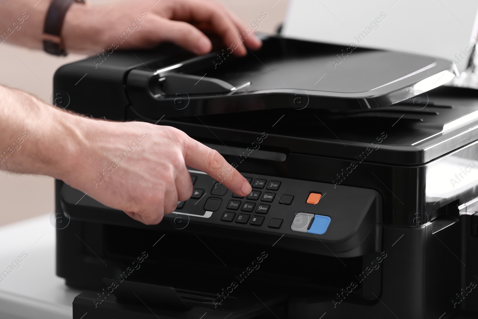 Photo of Employee using modern printer in office, closeup