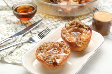 Photo of Delicious quinces baked with honey and walnuts on white table