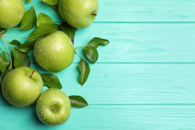 Photo of Fresh ripe green apples with water drops on turquoise wooden table, flat lay. Space for text