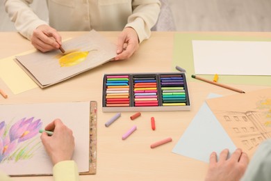 Photo of Artists drawing with soft pastels at table, closeup