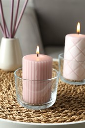 Burning candles and air reed freshener on table indoors