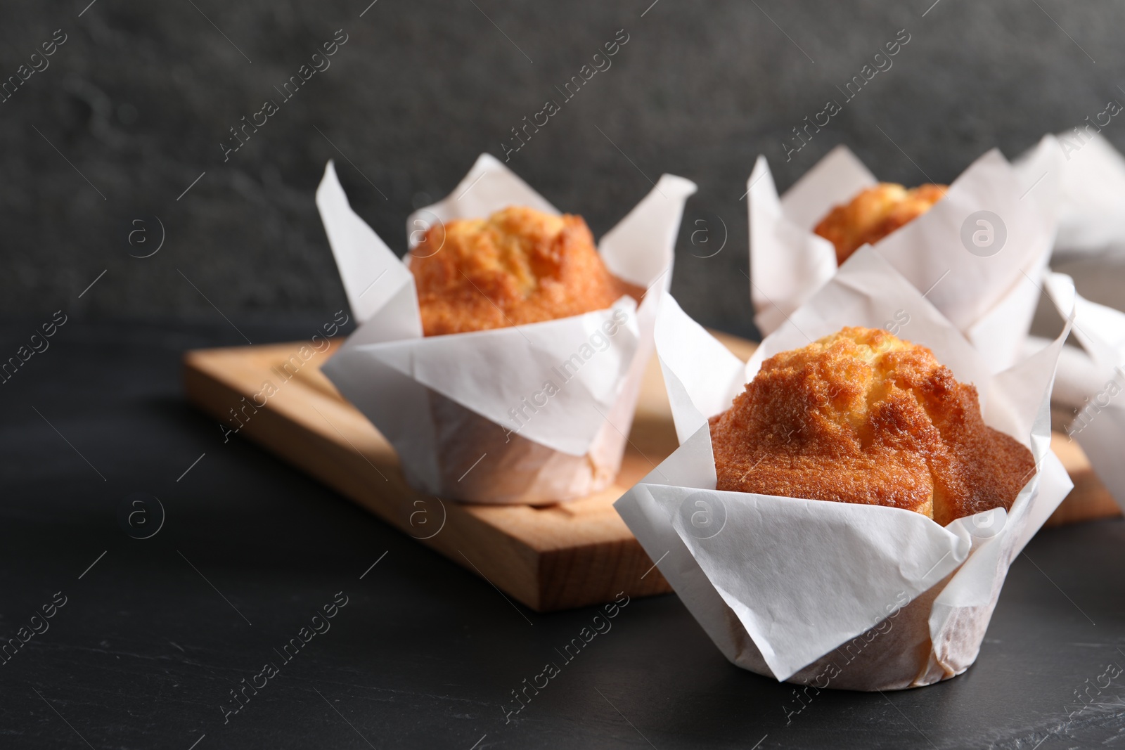 Photo of Tasty muffins on grey table, closeup. Fresh pastry