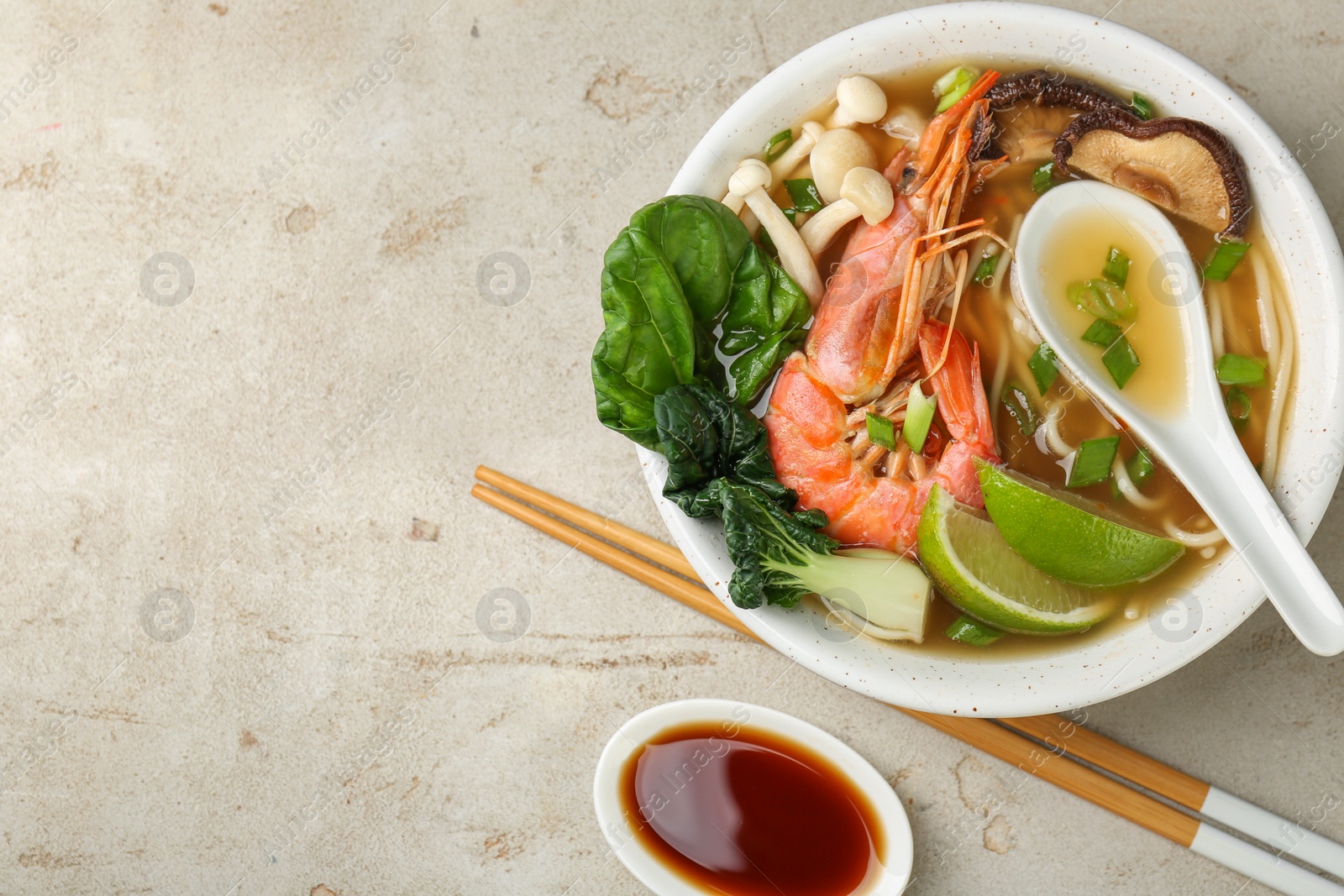 Photo of Delicious ramen with shrimps and mushrooms in bowl served on light textured table, flat lay and space for text. Noodle soup