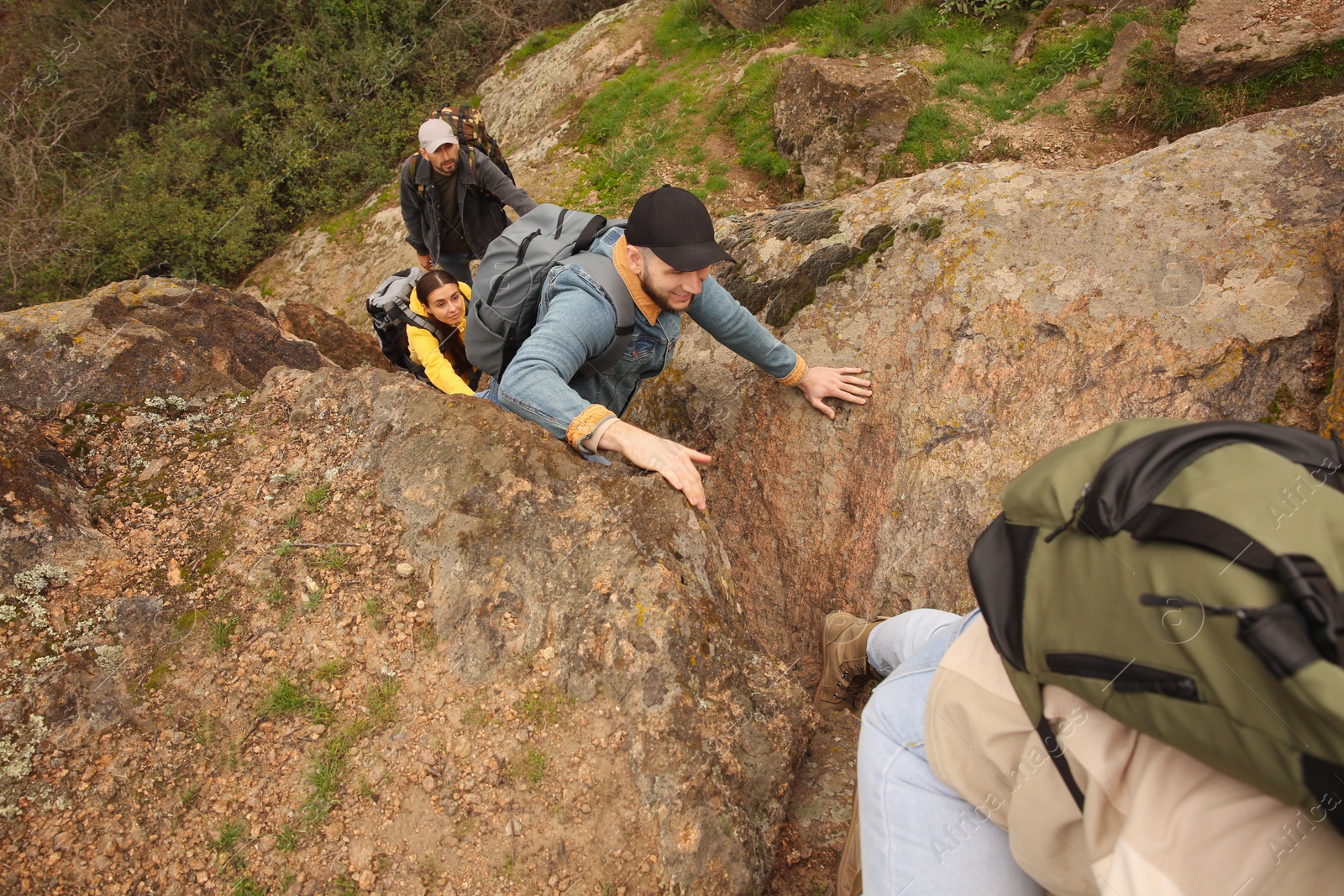 Photo of Group of hikers with backpacks climbing up mountains, above view