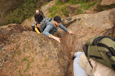 Photo of Group of hikers with backpacks climbing up mountains, above view
