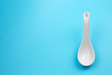 Clean empty miso spoon on blue background, space for text