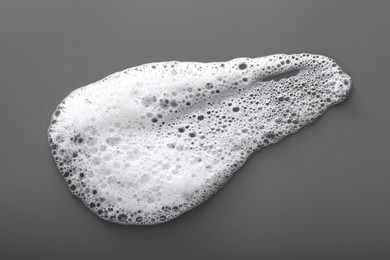 Photo of Smudge of white washing foam on dark gray background, top view
