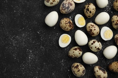 Peeled and unpeeled hard boiled quail eggs on black table, flat lay. Space for text