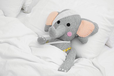 Photo of Toy elephant with bandages lying in bed