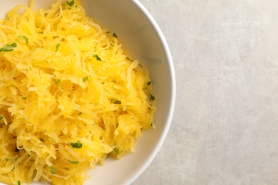 Bowl of cooked spaghetti squash on table, top view with space for text