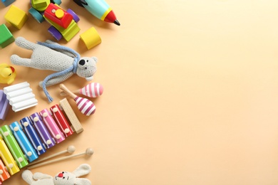 Different toys on beige background, flat lay. Space for text