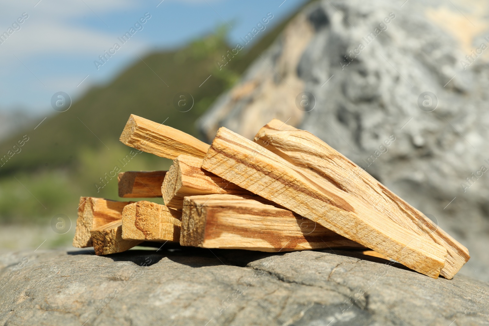 Photo of Many palo santo sticks on stone surface in high mountains, closeup