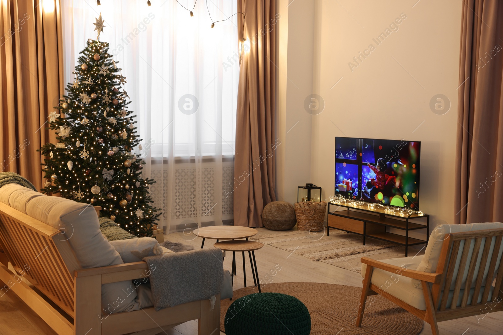 Photo of Wide TV set, furniture and Christmas tree in stylish room