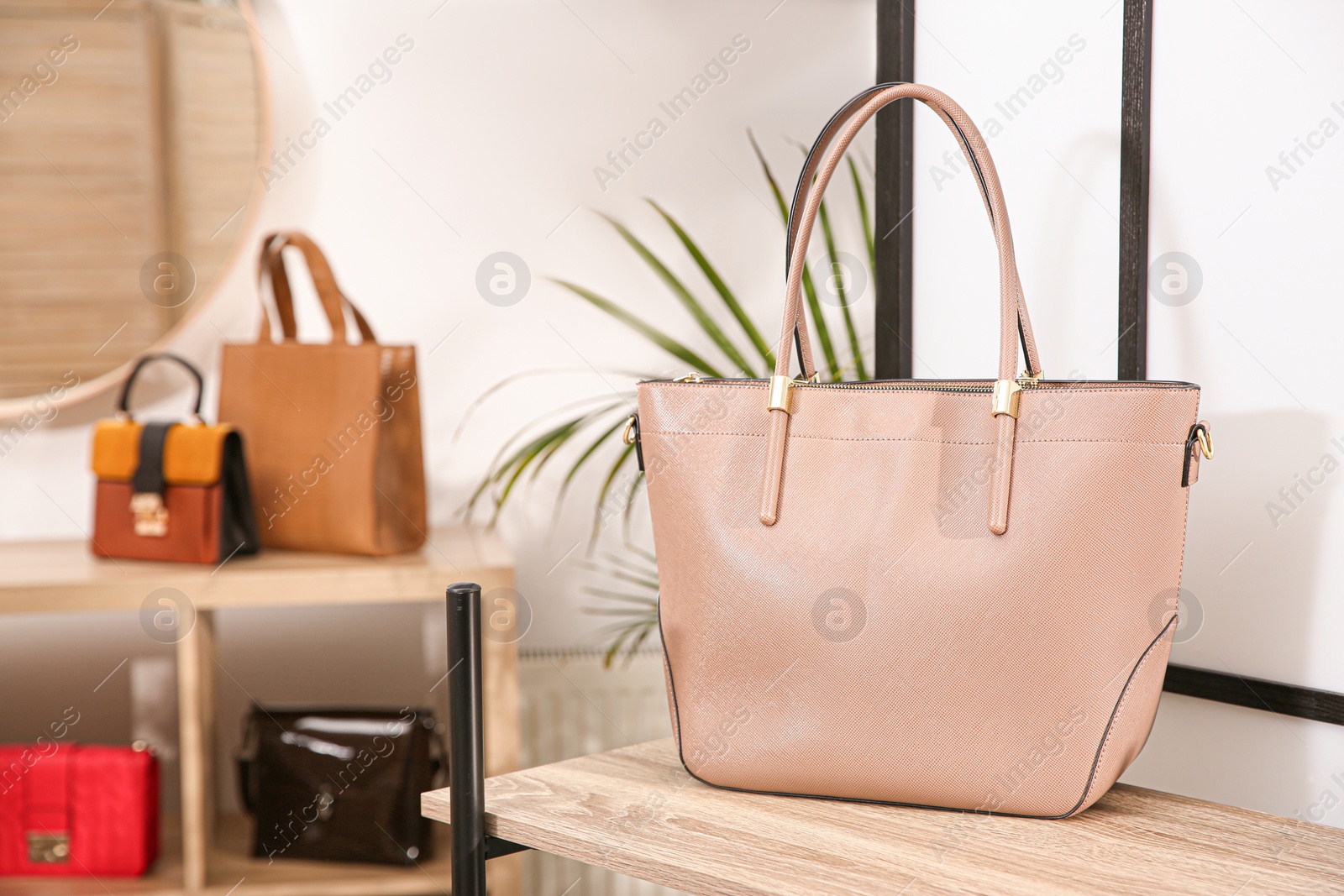 Photo of Beige woman's bag on wooden shelf in store