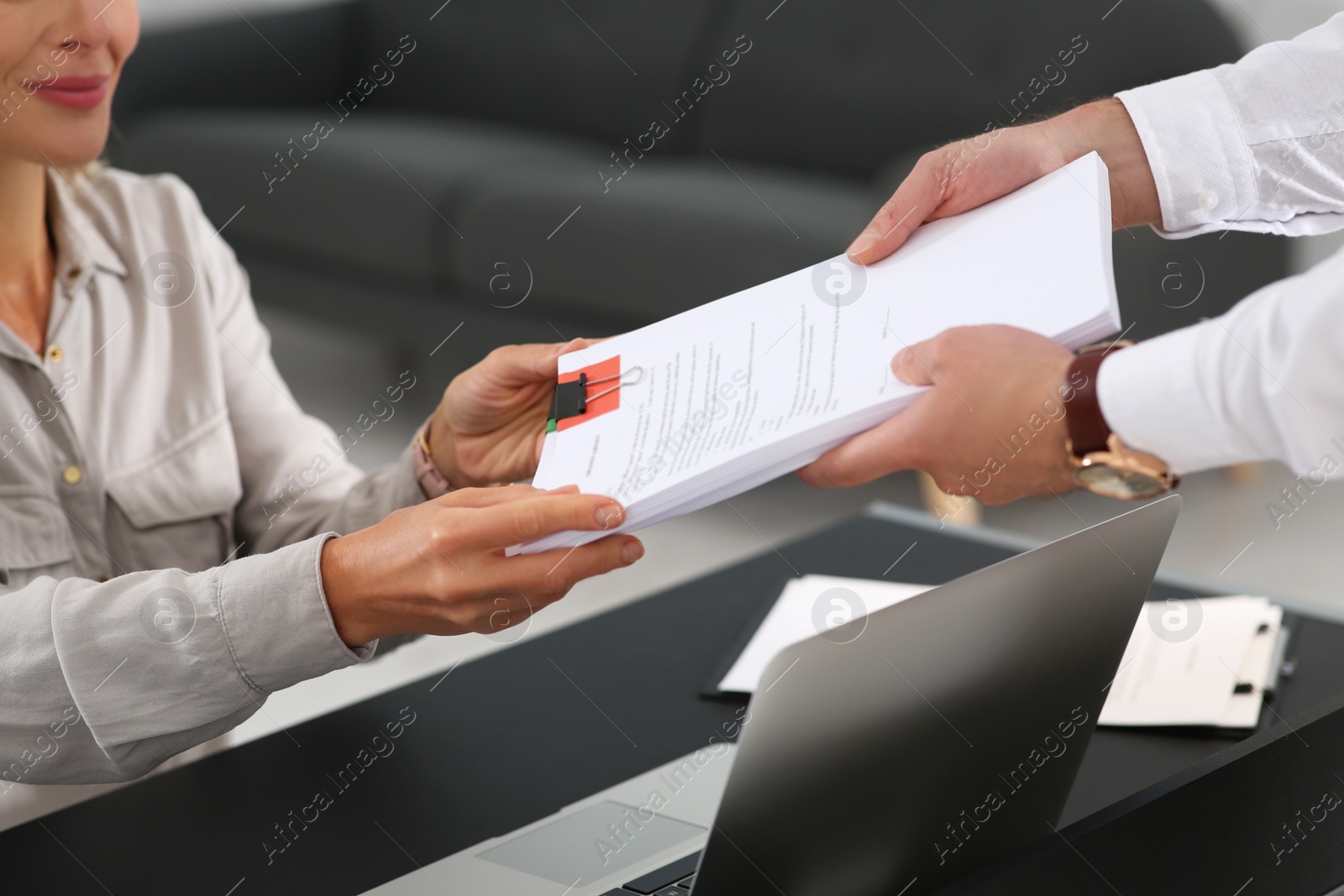 Photo of Woman giving documents to colleague in office, closeup