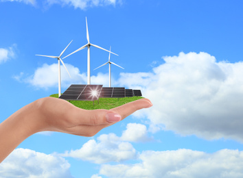 Image of Woman demonstrating solar panel outdoors, closeup. Alternative energy source 