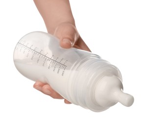 Woman holding feeding bottle with milk on white background, closeup