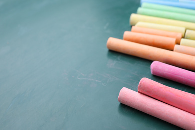 Pieces of color chalk on greenboard, space for text