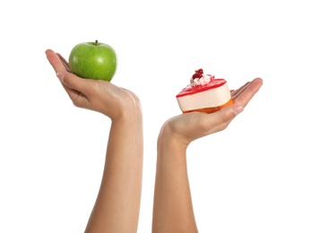 Concept of choice. Woman holding apple and cake on white background, closeup