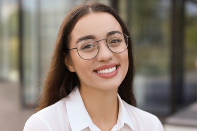 Photo of Portrait of beautiful woman in glasses outdoors. Attractive lady smiling and looking into camera