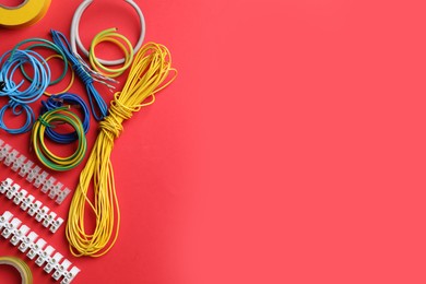 Flat lay composition with electrician's accessories on red background, space for text