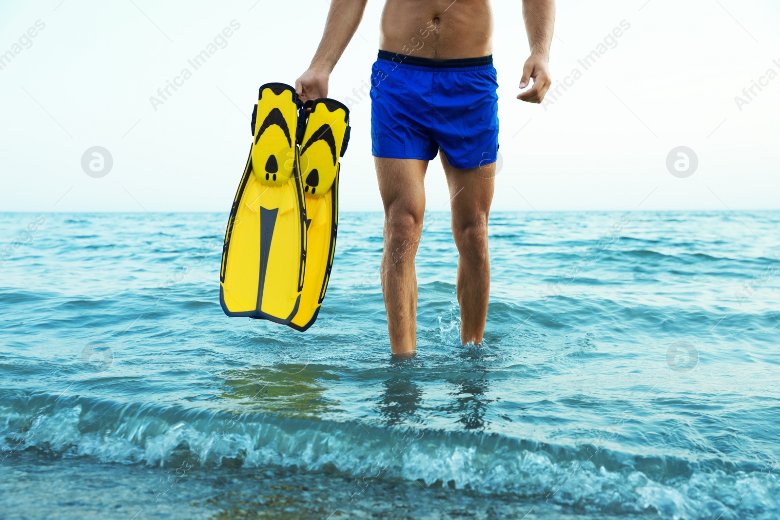 Photo of Man with flippers walking out of sea water, closeup