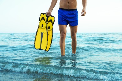 Photo of Man with flippers walking out of sea water, closeup
