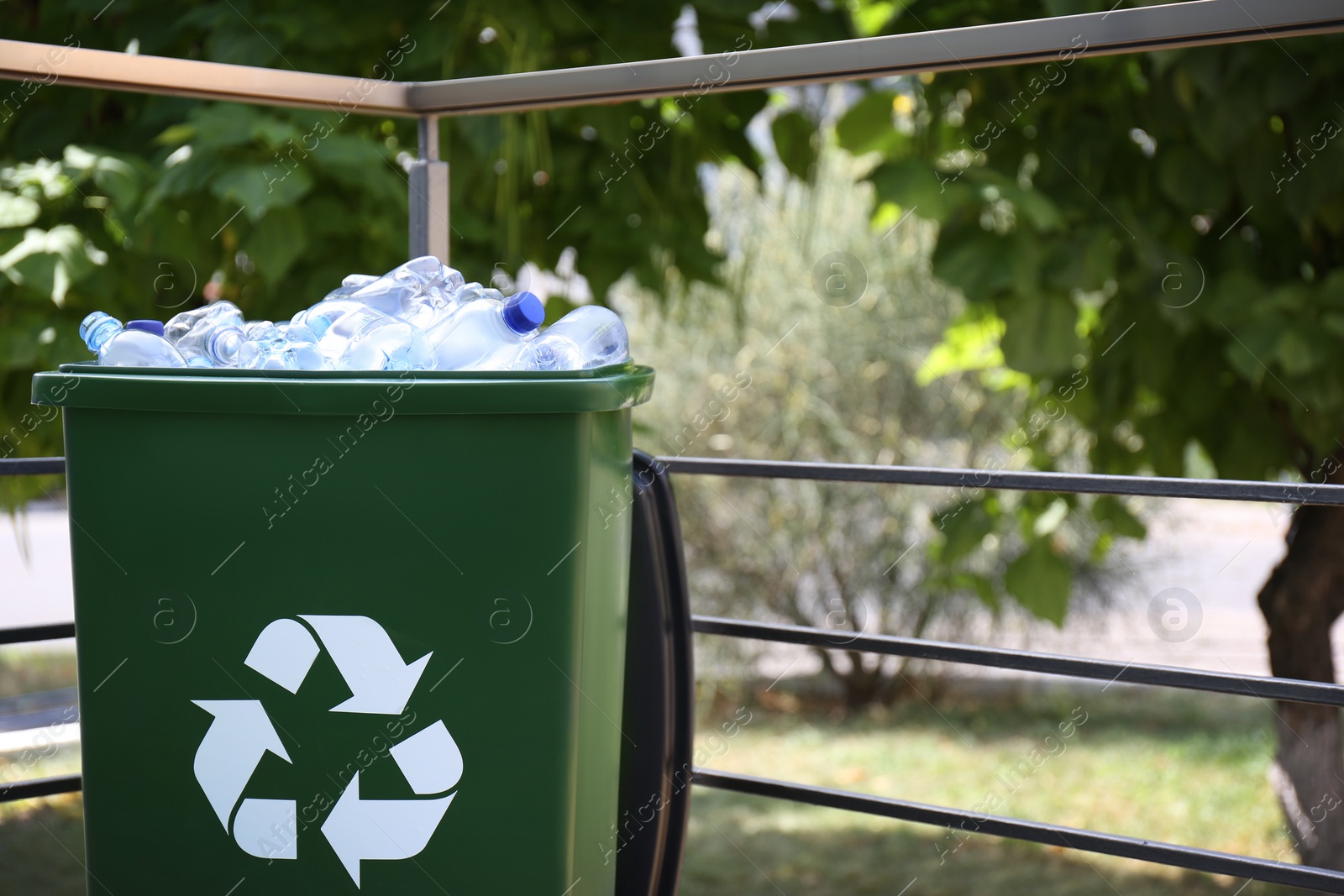 Photo of Many used plastic bottles in trash bin outdoors. Recycling problem