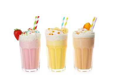 Photo of Glasses of tasty milk shakes on white background
