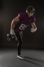 American football player wearing uniform on dark background