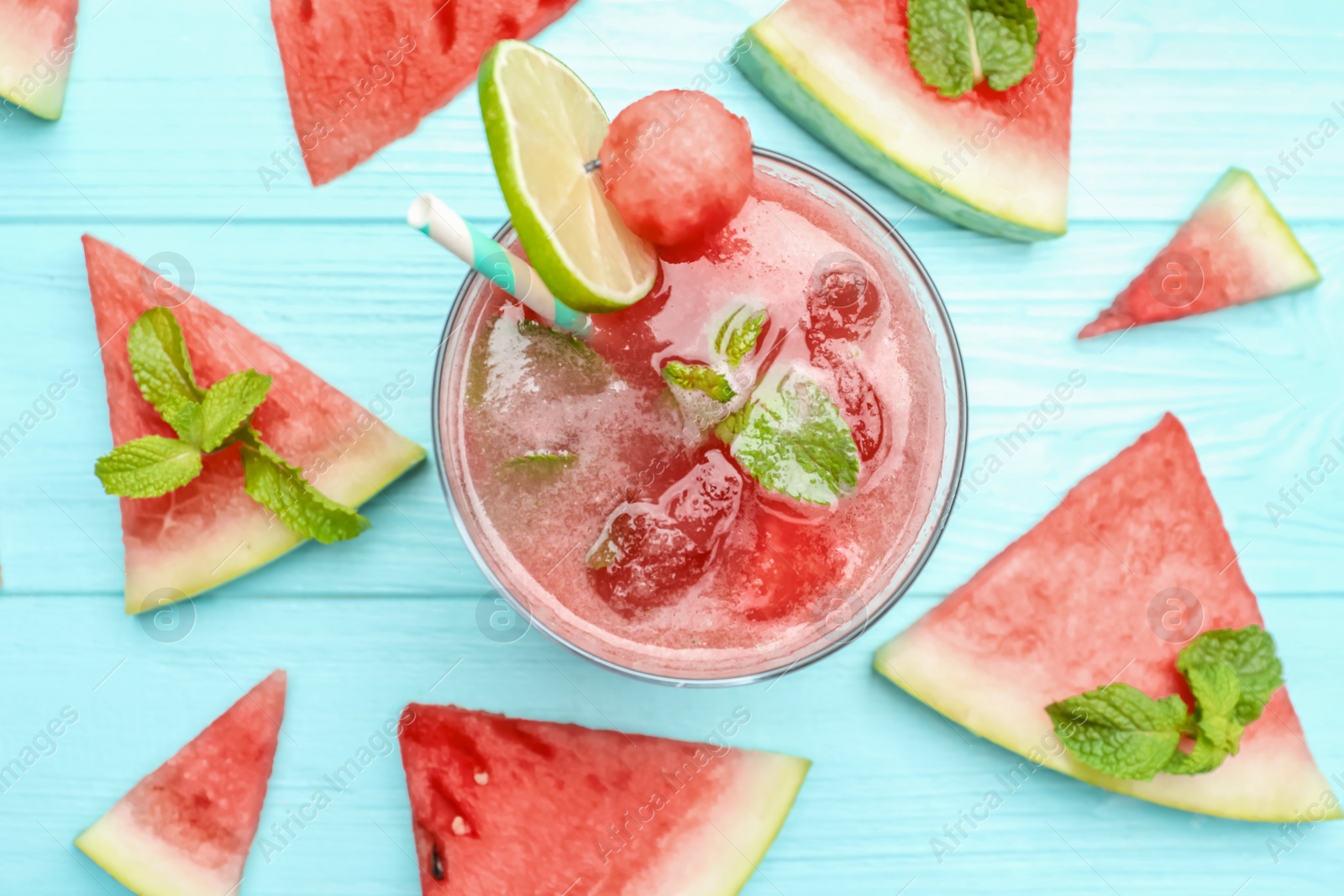 Photo of Delicious fresh watermelon drink on light blue wooden table, flat lay