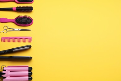 Flat lay composition of professional hairdresser tools on orange background, space for text