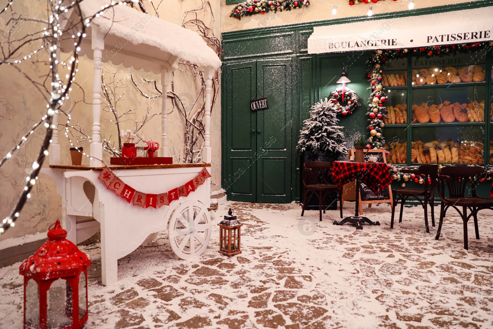 Photo of Stylish candy cart near outdoor cafe. Christmas holidays