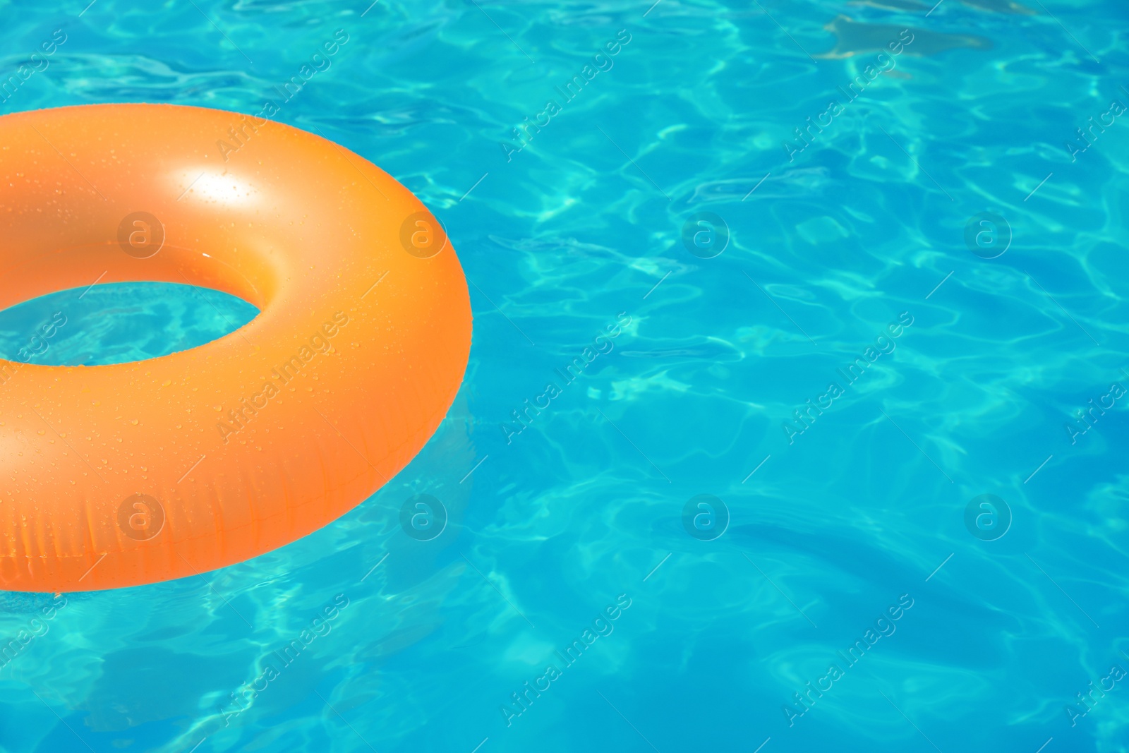 Photo of Inflatable ring floating in swimming pool on sunny day. Space for text