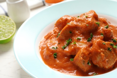 Photo of Plate of delicious butter chicken on table, closeup. Traditional Murgh Makhani dish