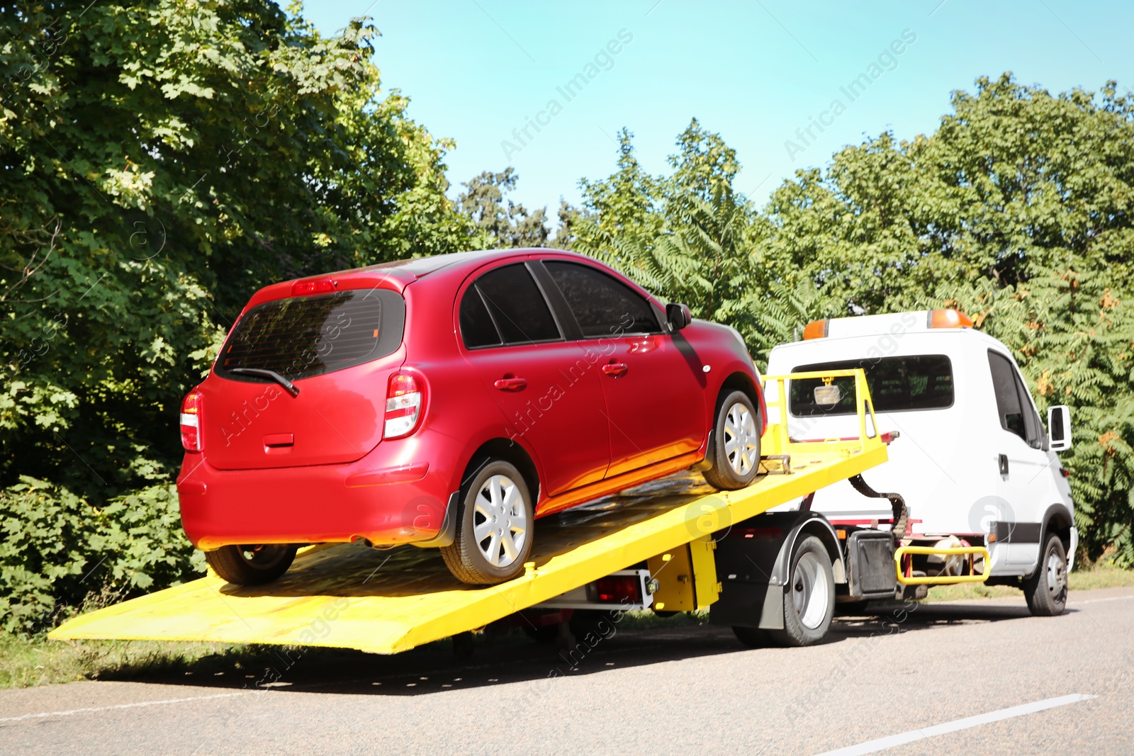 Photo of Tow truck with broken car on country road