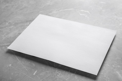 Blank paper sheet on light grey marble background. Mock up for design